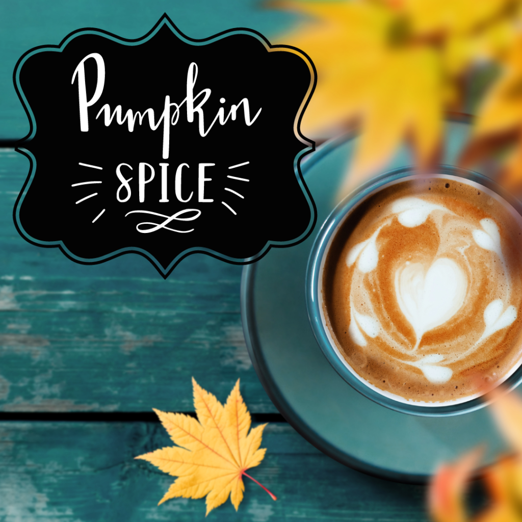 coffee cup filled with a latte and a sign that reads pumpkin spice
